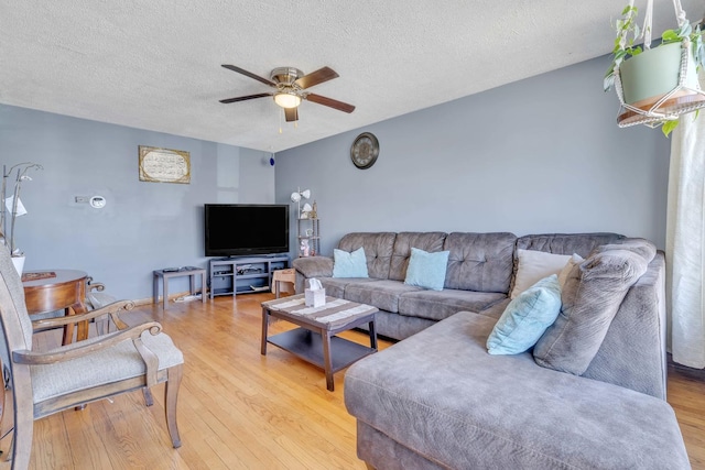 living room featuring a textured ceiling, light wood-style flooring, and a ceiling fan