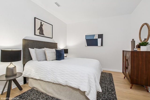 bedroom featuring visible vents, baseboards, and light wood-style flooring