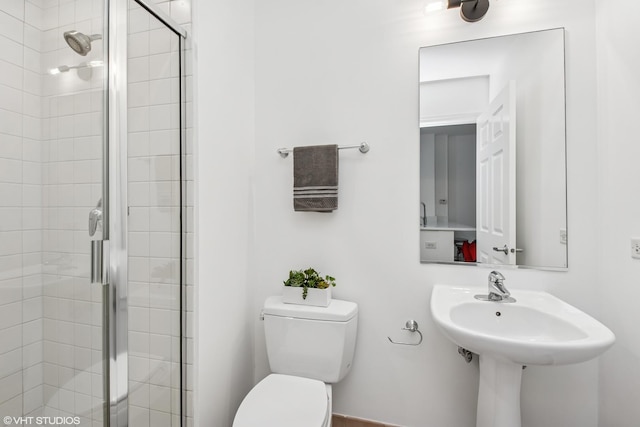 full bathroom featuring toilet, a sink, and a stall shower
