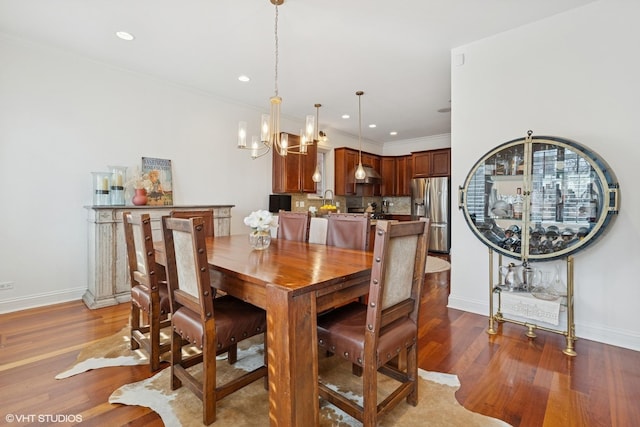 dining area featuring wood finished floors, baseboards, and a chandelier