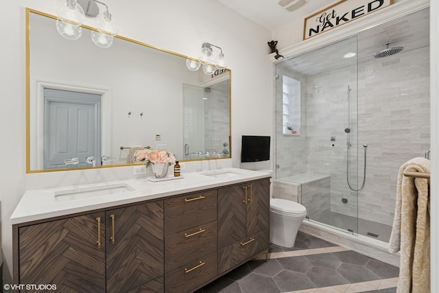 full bathroom featuring a shower stall, tile patterned floors, a sink, double vanity, and toilet