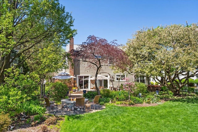 401 Aurora Ct, Vernon Hills, IL 60061 - back of house with a chimney, a patio area, a fire pit, and a lawn