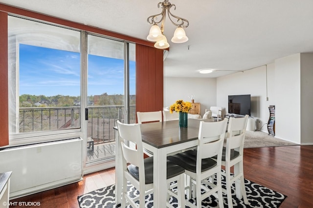 dining space featuring hardwood / wood-style floors and a chandelier