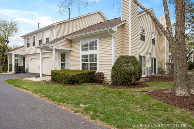 view of home's exterior featuring a chimney, driveway, and a lawn