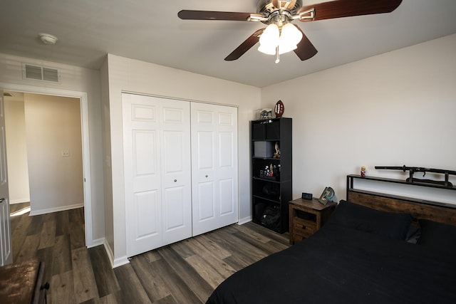 bedroom featuring visible vents, baseboards, wood finished floors, and a closet