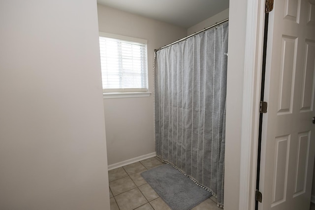 bathroom with a shower with curtain and tile patterned flooring