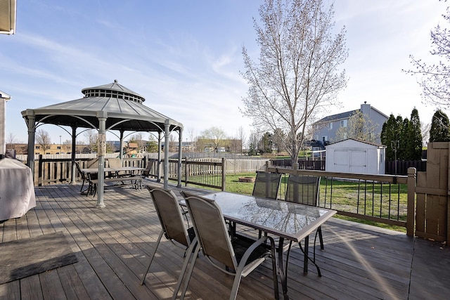 wooden deck with outdoor dining area, a fenced backyard, and a gazebo