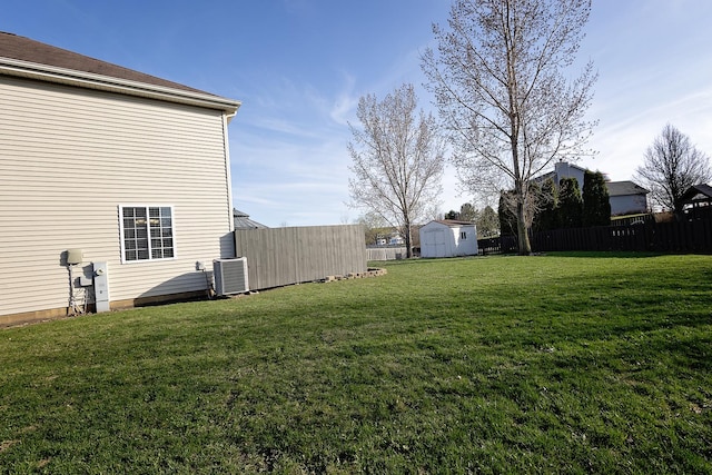 view of yard with an outbuilding, fence, a storage shed, and cooling unit