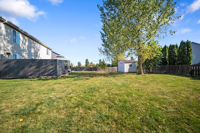 view of yard with a gazebo, a fenced backyard, an outbuilding, and a storage shed