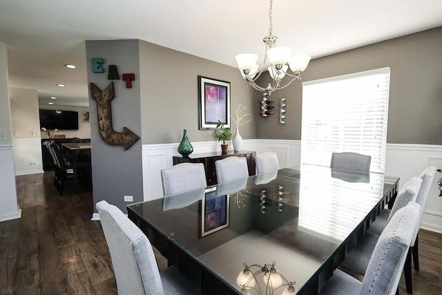 dining room featuring an inviting chandelier, wood finished floors, and a wainscoted wall