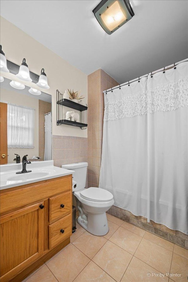 bathroom featuring tile patterned floors, vanity, tile walls, and toilet