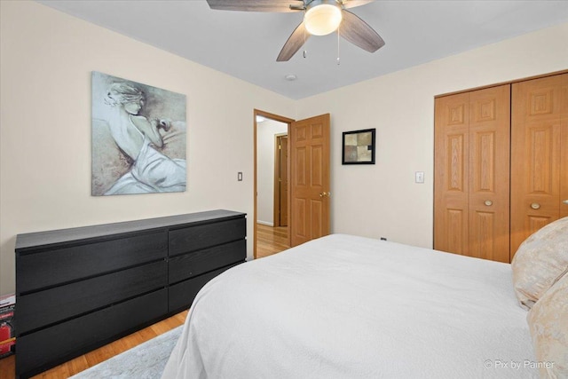 bedroom with light wood-style floors, a closet, and ceiling fan