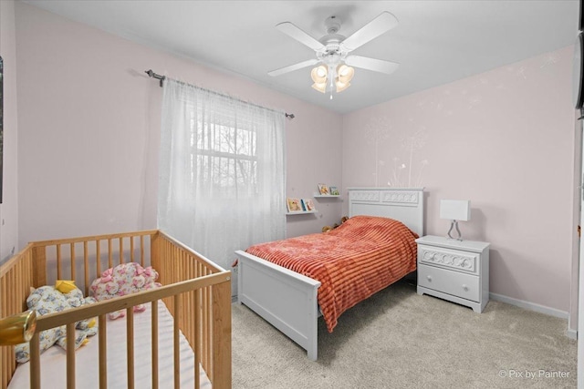 bedroom featuring light carpet and a ceiling fan
