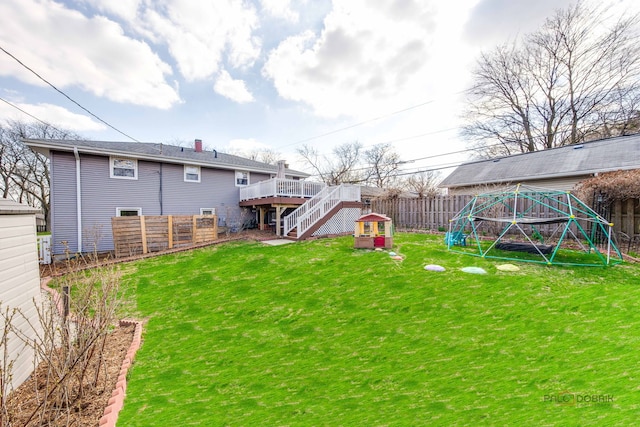 view of yard with a fenced backyard, a wooden deck, and stairway