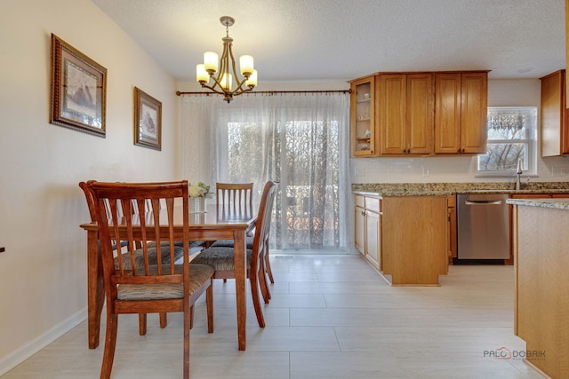 dining area featuring baseboards, a notable chandelier, and a textured ceiling