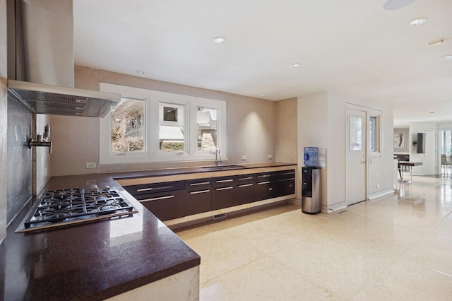 2441 Woodbridge Ln, Highland Park, IL 60035 - kitchen with dark brown cabinetry, dark countertops, stainless steel gas cooktop, island range hood, and a sink