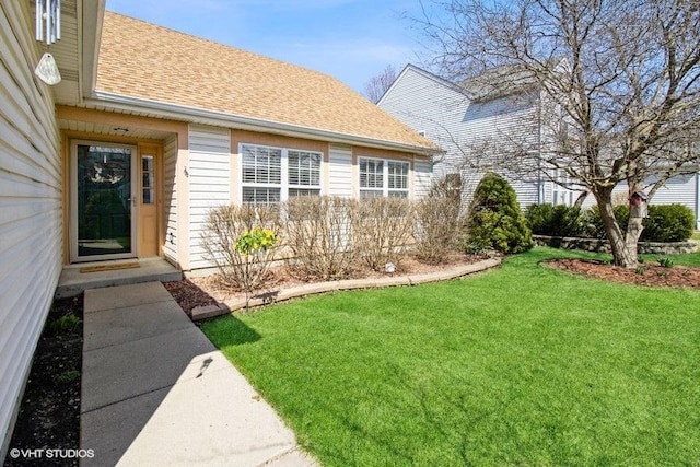 204 E Heritage Trl E, Hainesville, IL 60030 - view of exterior entry featuring roof with shingles and a yard