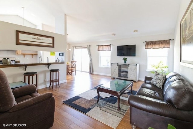 204 E Heritage Trl E, Hainesville, IL 60030 - living room featuring vaulted ceiling, wood finished floors, and baseboards
