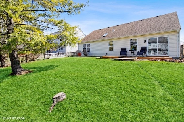 204 E Heritage Trl E, Hainesville, IL 60030 - back of house featuring fence, a wooden deck, a yard, and roof with shingles