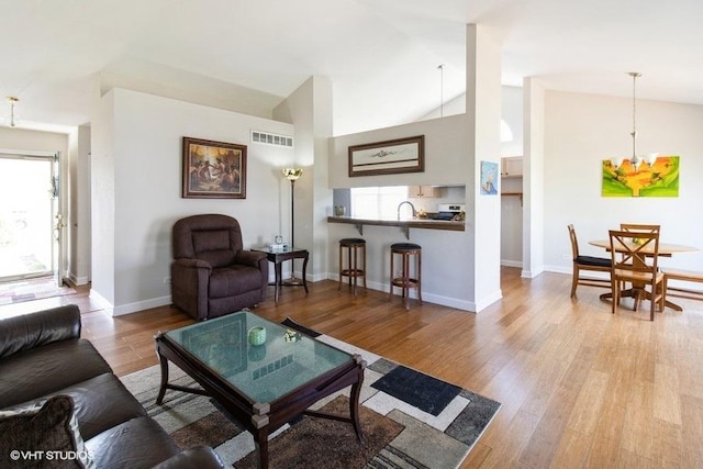 204 E Heritage Trl E, Hainesville, IL 60030 - living area with wood finished floors, visible vents, a healthy amount of sunlight, and a chandelier