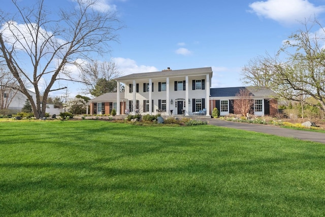 neoclassical / greek revival house featuring a porch and a front yard
