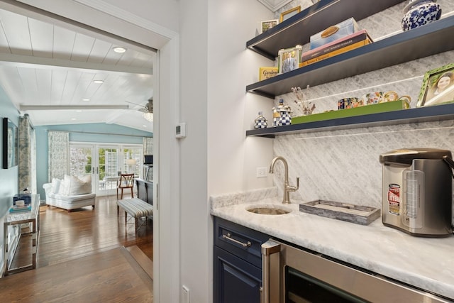 bar featuring beverage cooler, lofted ceiling with beams, indoor wet bar, a sink, and dark wood-style floors