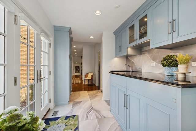kitchen featuring marble finish floor, visible vents, backsplash, and a wealth of natural light