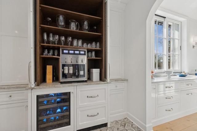 bar featuring arched walkways and wine cooler