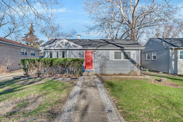 view of front of home featuring a shingled roof, a front lawn, and a chimney