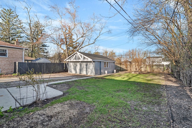 view of yard with a detached garage, an outbuilding, and fence