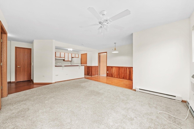 1580 W Sand Bar Ct Unit 1D, Round Lake Beach, IL 60073 - unfurnished living room with carpet flooring, a baseboard radiator, wainscoting, a ceiling fan, and wooden walls