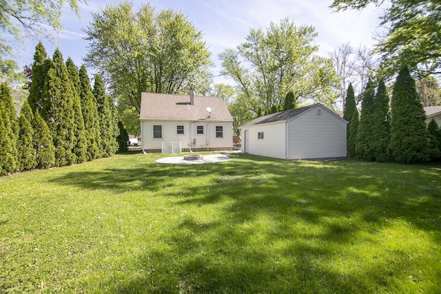 1357 Lennington Cir, Kankakee, IL 60901 - rear view of property featuring a yard, an outbuilding, a patio, and an outdoor fire pit