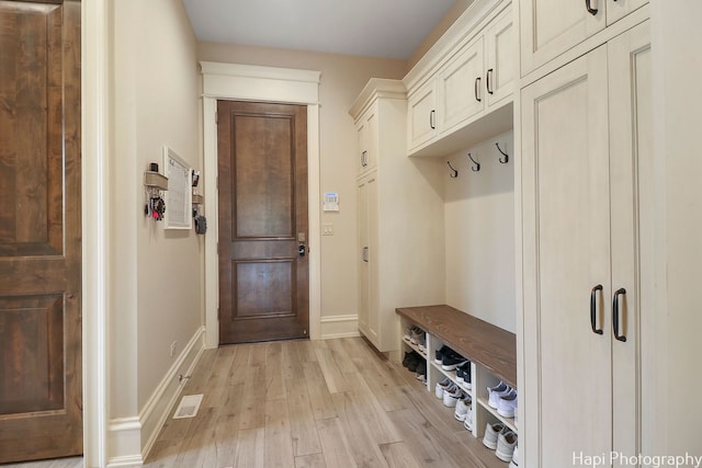 mudroom with light wood-style floors, baseboards, and visible vents