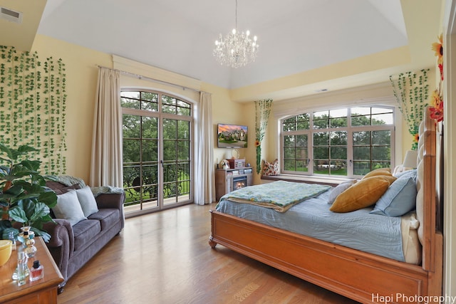 bedroom with visible vents, access to exterior, multiple windows, and a notable chandelier