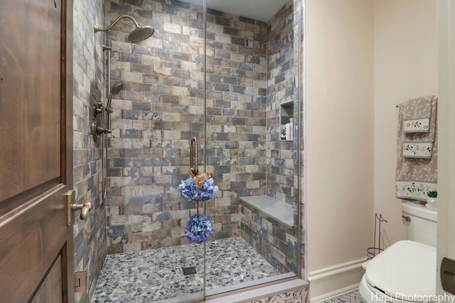 bathroom with a shower stall and toilet
