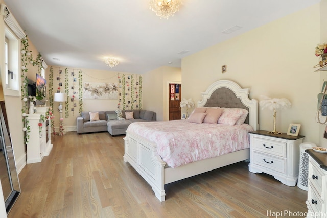 bedroom with a notable chandelier and wood finished floors