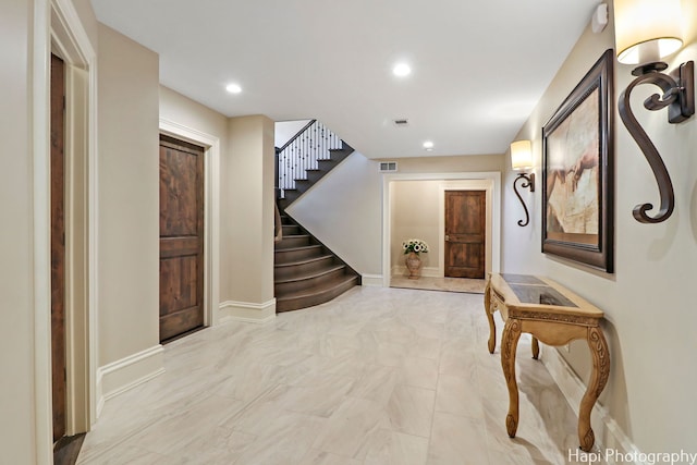 corridor with visible vents, baseboards, recessed lighting, and stairs