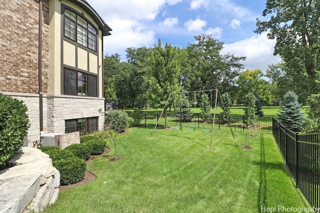 view of yard featuring fence and playground community