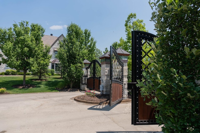 view of gate with a lawn