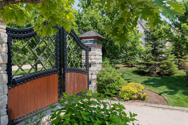 view of gate with a lawn