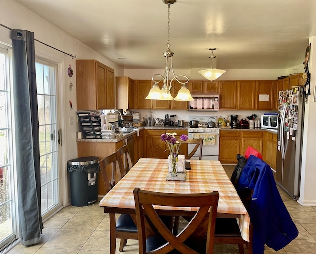 370 W Asbury Dr, Round Lake, IL 60073 - kitchen with appliances with stainless steel finishes, brown cabinets, light tile patterned floors, hanging light fixtures, and light countertops