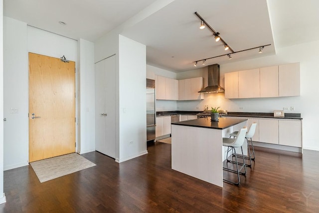 600 N Fairbanks Ct Unit 3610, Chicago, IL 60611 - kitchen with wall chimney range hood, dark wood-style floors, built in fridge, dark countertops, and a breakfast bar area
