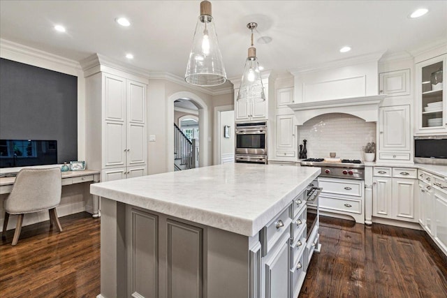 kitchen with dark wood-style floors, white cabinetry, backsplash, appliances with stainless steel finishes, and arched walkways