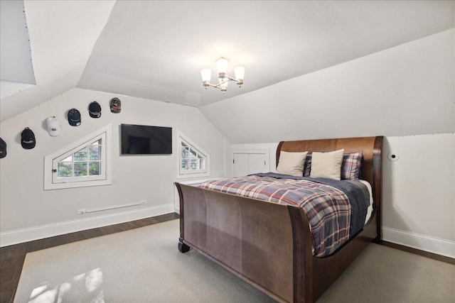 bedroom with a notable chandelier, baseboards, wood finished floors, and lofted ceiling