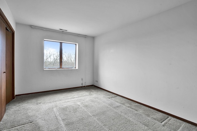 unfurnished bedroom with carpet flooring, visible vents, a closet, and baseboards