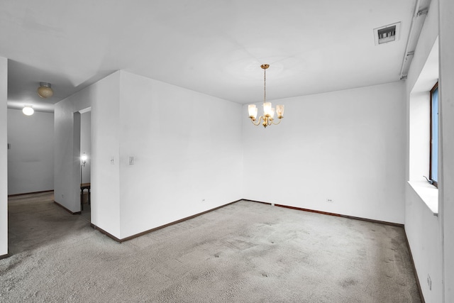 carpeted empty room with visible vents, baseboards, and a notable chandelier