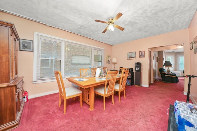 dining room featuring carpet, a textured ceiling, baseboards, and ceiling fan