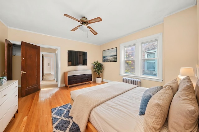 bedroom with light wood-style flooring, crown molding, radiator heating unit, and ceiling fan