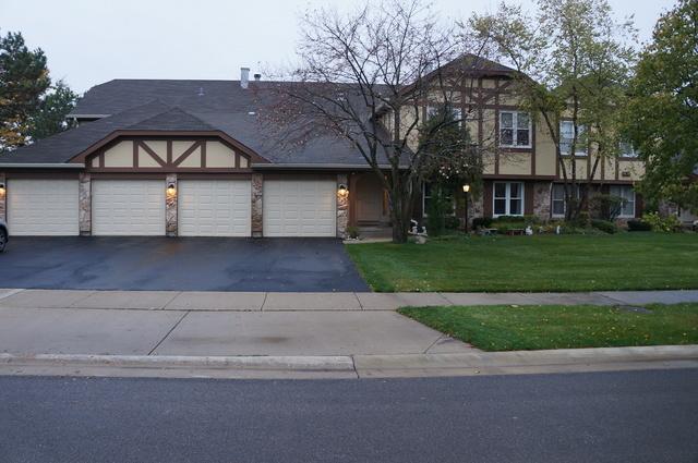 1304 N Streamwood Ln Unit 309, Vernon Hills, IL 60061 - tudor house featuring asphalt driveway, a front lawn, and a garage