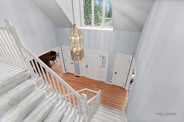 318 Camelot Ln, Libertyville, IL 60048 - foyer featuring a chandelier, wood finished floors, stairs, and high vaulted ceiling